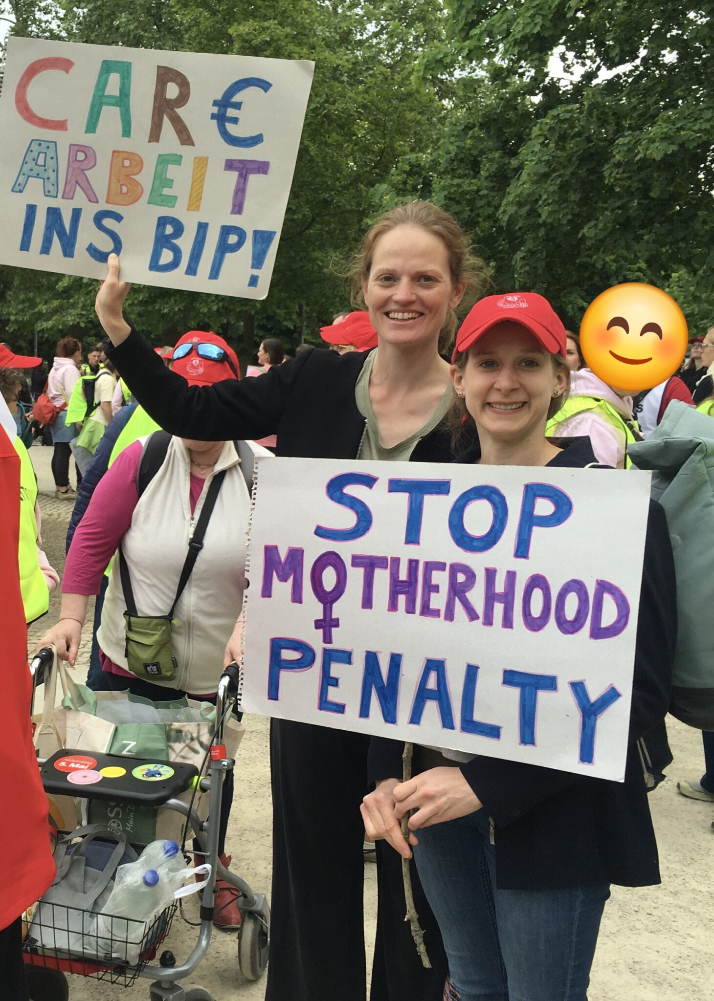 Hanna Dude und Judith Münter auf Demo in Berlin mit Plakaten 'Stop Motherhood Penalty' und 'Care-Arbeit ins BIP'